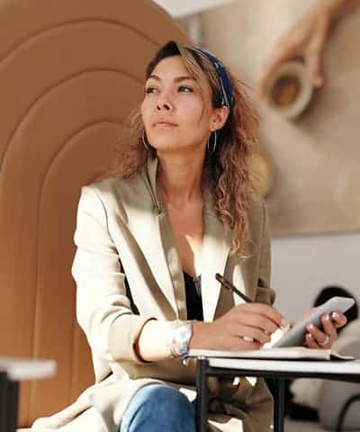 woman wearing blazer and blue denim jeans sitting on chair woman wearing blazer and blue denim jeans sitting on chair
